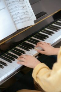 Close-up of a woman playing piano with sheet music, capturing musical talent and concentration.