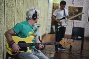 Two musicians recording in a Buenos Aires studio playing electric guitars.